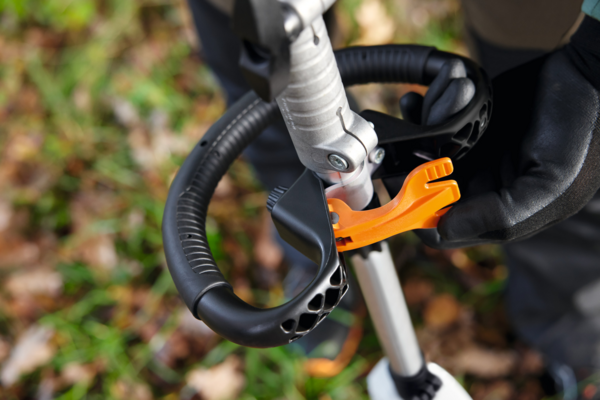 Person bedient Stihl KMA 120 R Akku-KombiMotor mit ergonomischen Griffen im Freien
