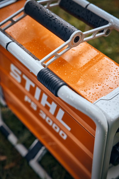 Nahaufnahme eines mobilen Stromgenerators STIHL PS 3000 mit Wassertropfen auf orangefarbenem Gehäuse