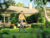 Person mit Stihl Motorsense im Garten vor einem Haus