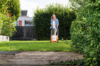 Frau benutzt STIHL RMA 339 Rasenmäher in einem sonnigen Garten