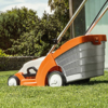STIHL RMA 339 Rasenmäher auf grünem Rasen vor modernem Haus