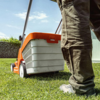 Person mäht Rasen mit STIHL RMA 339 Rasenmäher in sonnigem Garten