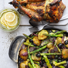 Gegrilltes Hähnchen mit gebratenen Kartoffeln Spargel Zwiebeln Oliven auf Holzbrett