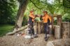 Zwei Forstarbeiter in Stihl Bundhosen und Schutzausrüstung unterhalten sich in einem Wald