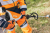 Person in STIHL Schutzausrüstung bedient einen Freischneider auf einer Wiese