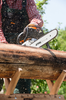 Person sägt Holzstamm mit STIHL Motorsäge im Freien