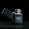 Schwarzes O'Donnell Moonshine Benzinfeuerzeug mit geöffneter Klappe auf dunklem Hintergrund