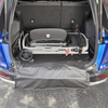 Weber Traveler Grill im Kofferraum eines blauen Autos mit speziellem Schutz