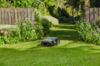 STIHL iMOW 7 EVO Mähroboter mäht Rasen in einem sonnigen Garten