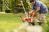 Mann verwendet STIHL KombiMotor im Garten für Trimmerarbeiten