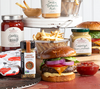Burger mit Beilagen und Stonewall Kitchen Saucen auf Holzbrett