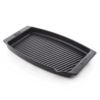 Schwarze Weber BBQ Keramik-Grillpfanne mit geriffeltem Boden auf dunkelgrünem Hintergrund