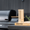 MEATER Pro Duo smartes Fleischthermometer auf Holzbasis vor modernem Grill