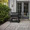Weber SEARWOOD XL Holzpelletgrill vor einem modernen Haus mit Holzverkleidung