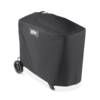 Weber Traveler Premium Abdeckhaube über einem Grill mit sichtbarem Weber-Logo