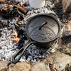 Petromax Kasserolle aus Gusseisen auf glühenden Kohlen eines Lagerfeuers
