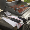 Weber Premium Grillbesteck auf einem Gasgrill mit gegrilltem Fleisch