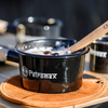 Petromax Emaille Stieltopf mit Porridge auf Holzuntergrund im Freien