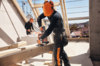 Zwei Männer sägen Holz auf Baustelle mit STIHL Akku-Kettensäge