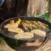Weber Master-Touch Grill mit Fisch und Spargel in einem Garten