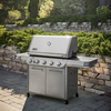 Weber Summit FS38 S Gasgrill in einem Garten mit Steinmauer und Grün