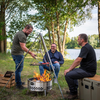 Drei Männer genießen ein Grillfest am See mit einer Petromax Feuerschale Tyropit