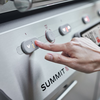 Hand bedient Touchscreen-Bedienknopf am Weber Summit Smart Grill