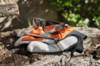 STIHL Schutzbrille auf Arbeitshandschuhen und Gesichtsschutz, platziert auf einem Holzstamm im Freien