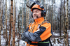 Älterer Forstarbeiter in STIHL Schutzausrüstung mit Visierverlängerung im schneebedeckten Wald