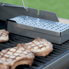 Weber Räucherbox aus Edelstahl auf einem Gasgrill mit gegrilltem Fleisch
