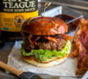 Burger mit Speck und Salat, Rufus Teague BBQ Sauce im Hintergrund