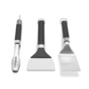 Weber Griddle Grillwerkzeug-Set mit Grillwender, Grillzange und Grillschaber auf grünem Hintergrund