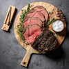 Gegarter Rinderbraten auf Holzbrett mit MEATER Plus Thermometer und Kräutern