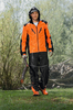 Mann in Stihl Wetterschutz-Bundhose und -jacke hält Ast im Regen