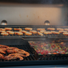 Weber Grill mit Garnelen, Gemüse im Grillkorb und geröstetem Baguette