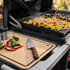 Weber Works Schneidebrett auf Seitentisch neben aktiver Plancha mit Gemüse