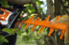 Nahaufnahme einer Stihl HSA 130 T Akku-Heckenschere beim Schneiden von Hecken