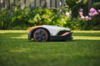 STIHL iMOW 5 Mähroboter auf grünem Rasen mit Gartenhintergrund