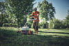 Mann benutzt STIHL Akku-Mulchrasenmäher in einem sonnigen Park
