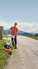 Professioneller Gärtner bedient Stihl Rasenmäher auf Landstraße