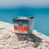 Packung Murray River Salt Flakes auf sandiger Oberfläche vor blauem Wasser