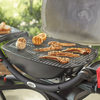 Weber Gasgrill Q2000 mit Lammkoteletts und Zitronen auf sauberem Grillrost im Garten