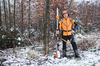 Forstarbeiter in STIHL Schutzausrüstung mit Motorsäge im verschneiten Wald