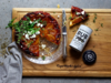 Tarte Tatin garniert mit Kräutern und Käse neben Cape Herb Rub Gewürzdose