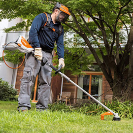 Mann verwendet Stihl KMA 130 R Akku-KombiMotor für Gartenarbeit