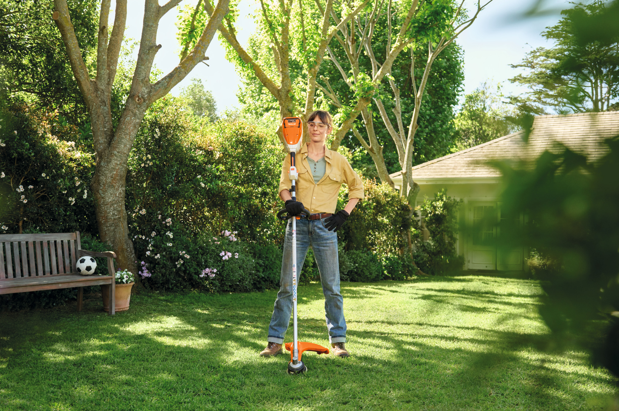 Frau in Garten mit Stihl FSA 80 R Motorsense bereit für Rasenpflege