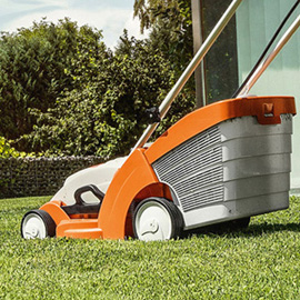 STIHL RMA 339 Rasenmäher auf grünem Rasen vor modernem Haus