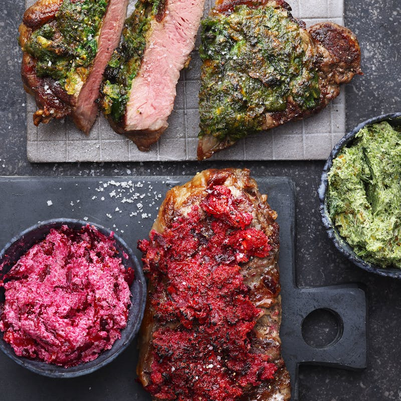 Gegrilltes Steak mit Kräuterkruste und Beilagen auf rustikalem Untergrund