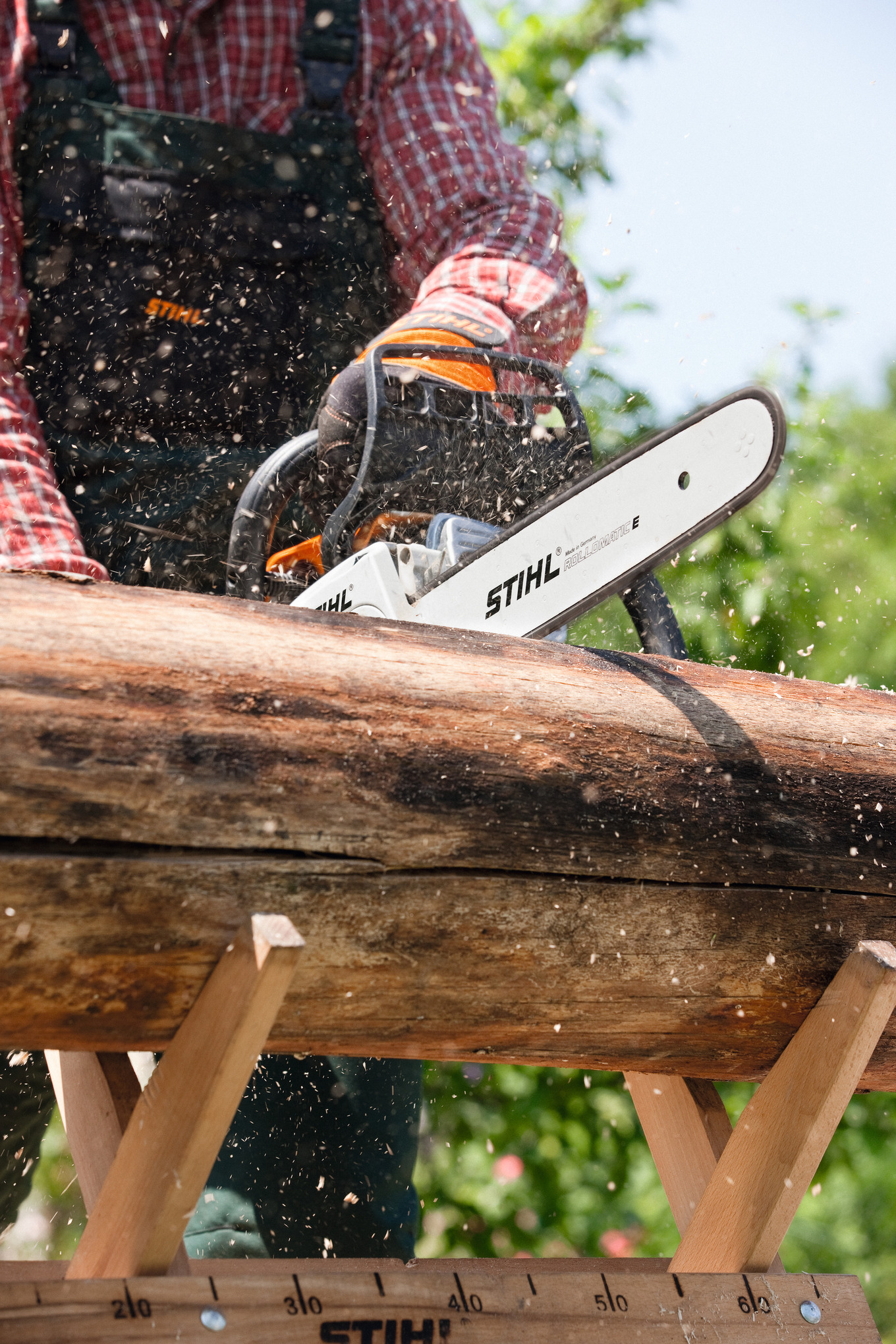 Person sägt Holzstamm mit STIHL Motorsäge im Freien