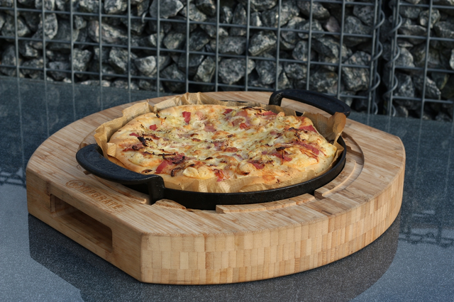 Pizza auf Bambus-Schneidebrett in Außenküche
